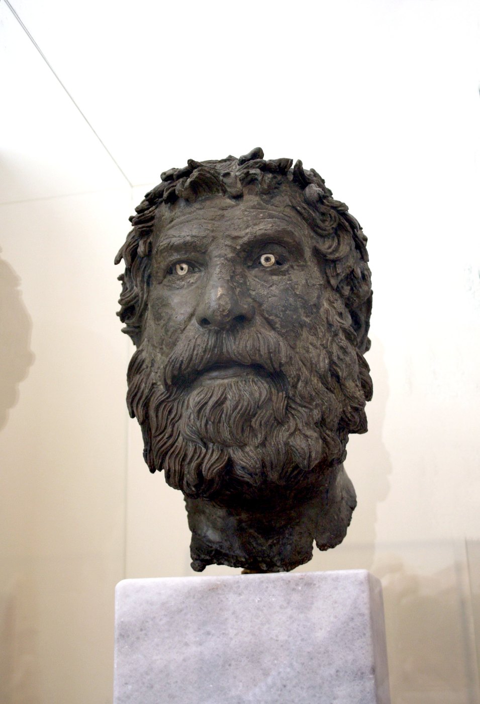 Figure 6 — The "Antikythera Philosopher", a bronze head of about 240 BC from a full-length statue found in the wreck, perhaps the Cynic Bion of Borysthenes. The eyes are inlaid with glass paste. National Arch…