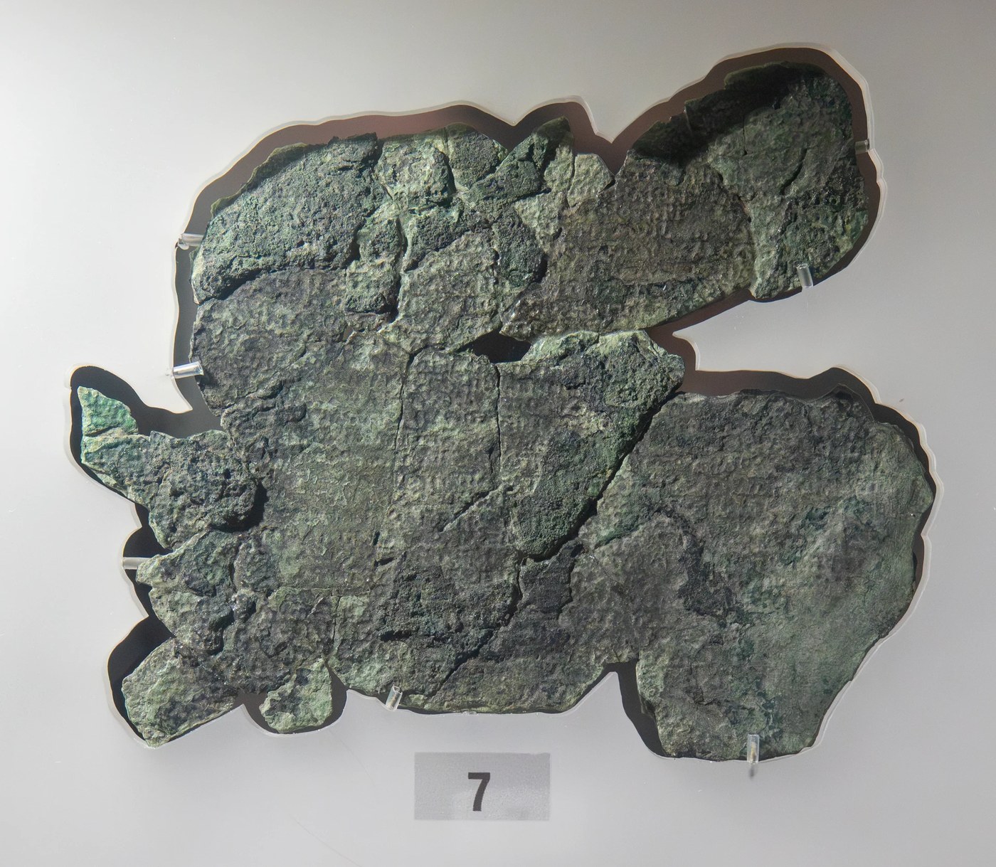 Figure 1 — Fragment G in its display mount in the National Archaeological Museum, Athens. The rows of tiny letters faintly visible across the surface belong to the Front Cover Inscription, the plate that lay …