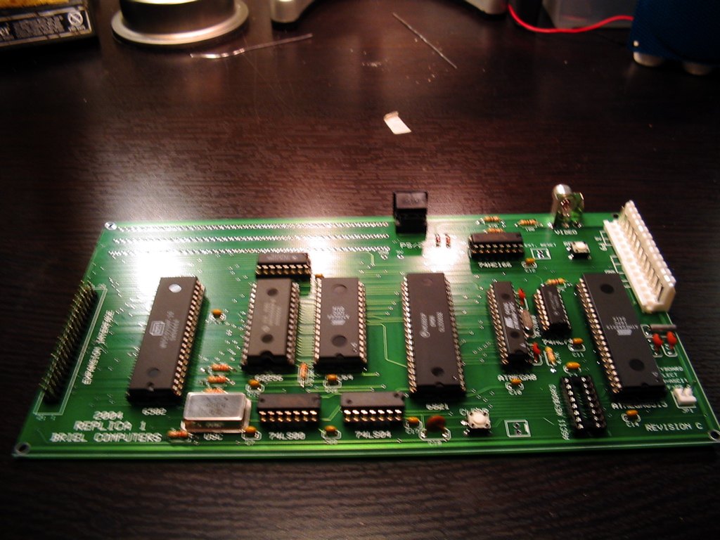 Figure 1 — A Briel Replica 1 (the 2004 revision C board) fully assembled: the 6502 and 6821 PIA, static RAM, EEPROM, the two microcontrollers that stand in for the video terminal and keyboard interface, and a…