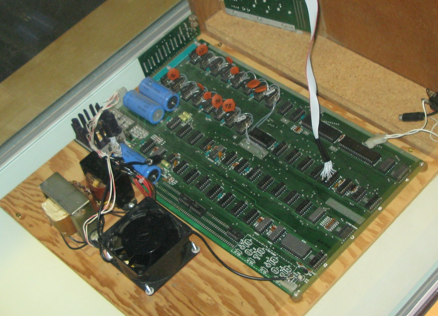 Figure 6 — An assembled Apple-1 with its cassette interface, shown in a home-made case with owner-added wiring, transformers and a cooling fan. Owners' modifications like these are part of a board's history; …
