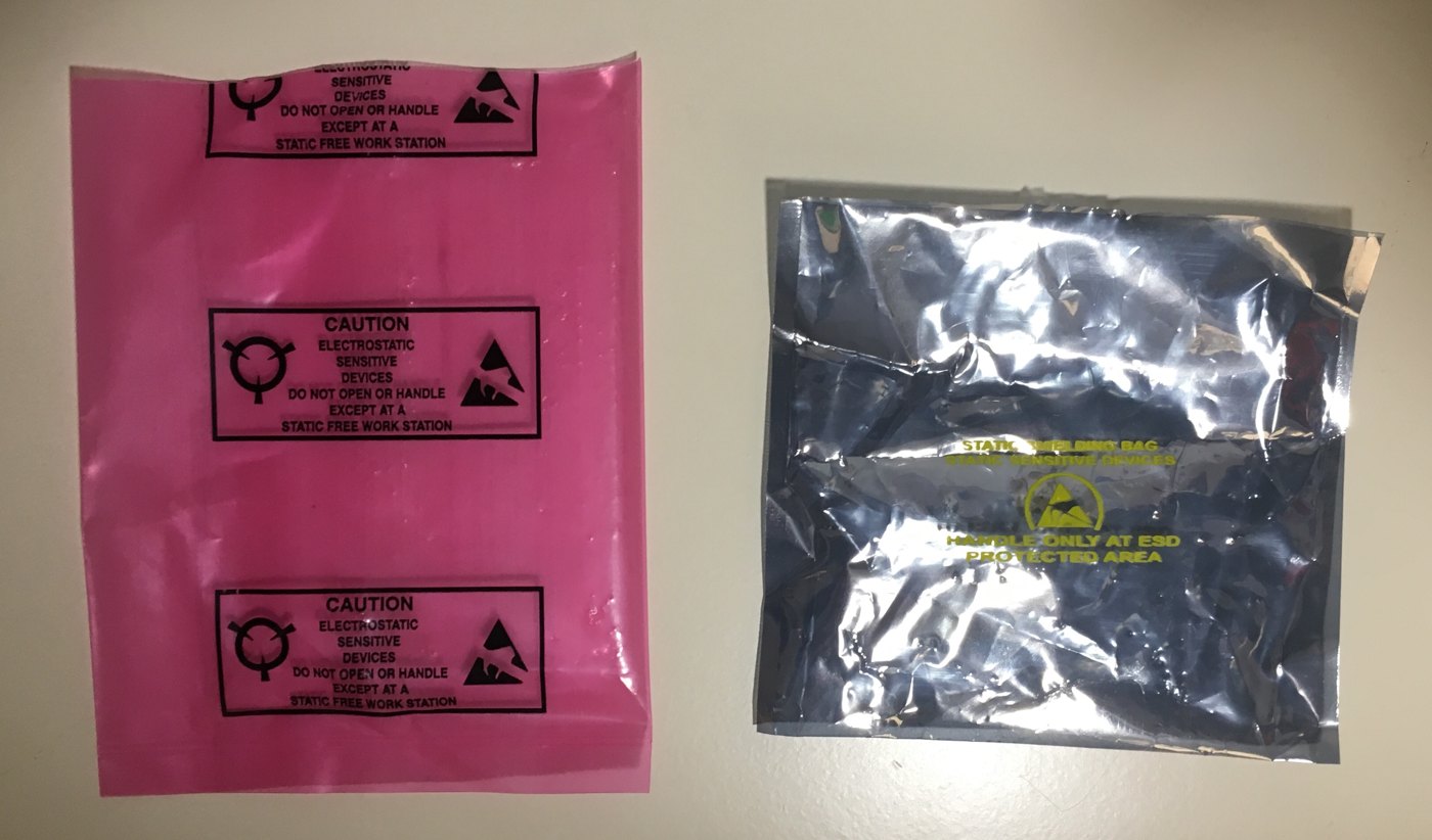 Figure 3 — Two kinds of "anti-static" bag. The pink one (left) is dissipative: it does not build up charge itself, but it does not shield what is inside. The grey metallised one (right) is a static-shielding …