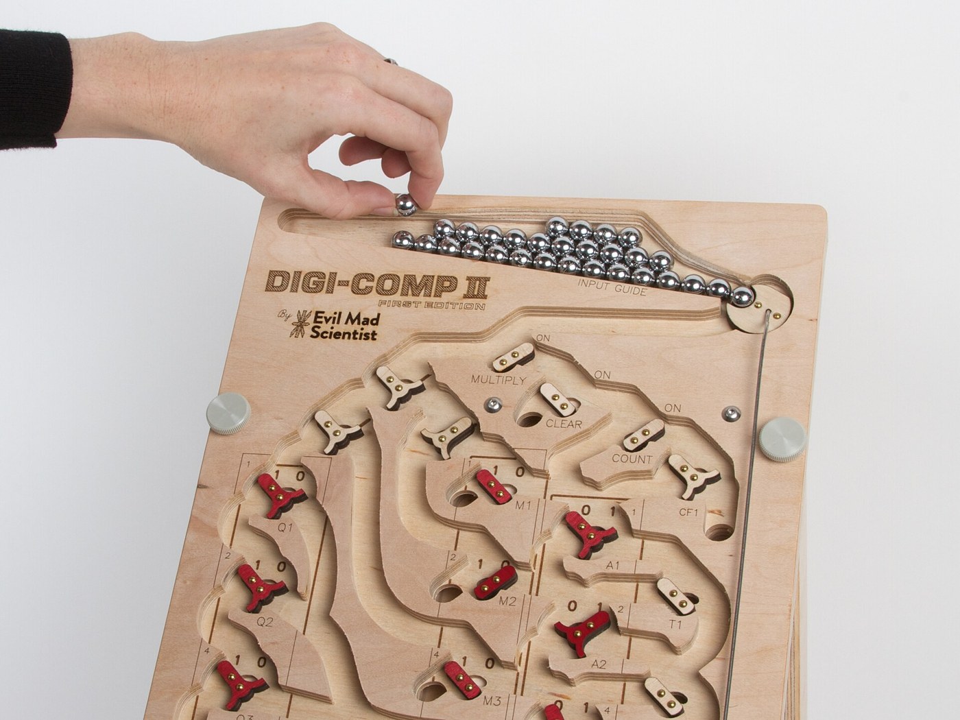 Figure 8 — Loading balls into the input guide of the plywood reproduction. On any Digi-Comp II the supply has to cover the whole operation: 29 balls for the largest multiplication.