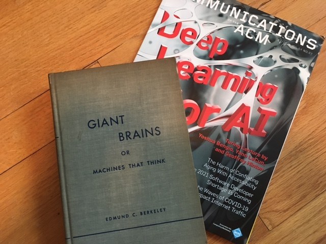 Figure 2 — Edmund C. Berkeley's Giant Brains, or Machines That Think (1949), photographed beside a 2021 issue of Communications of the ACM, the journal of the association he helped found in 1947. The book pop…