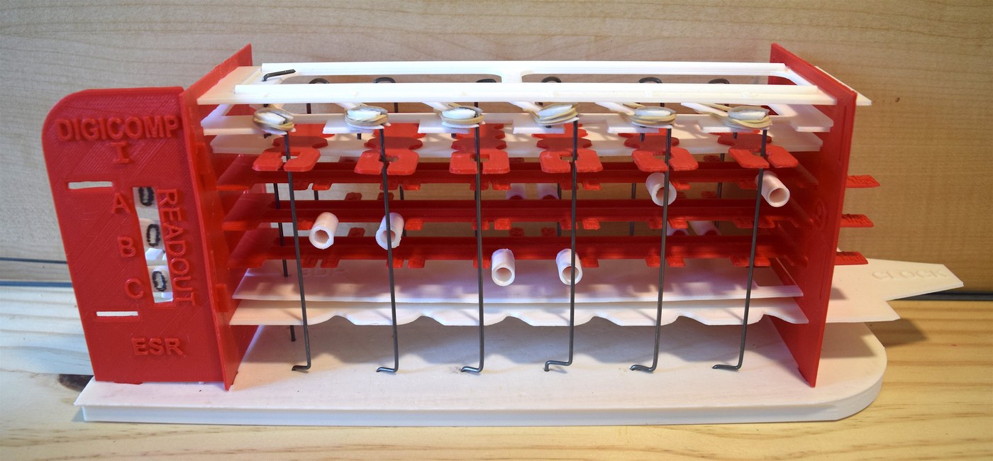 Figure 6 — Mark Ziemer's 3D-printed Digi-Comp I (2016), in red and white like the original, with music-wire logic rods and drinking-straw pegs. The parts were drawn from photographs and drawings preserved by …