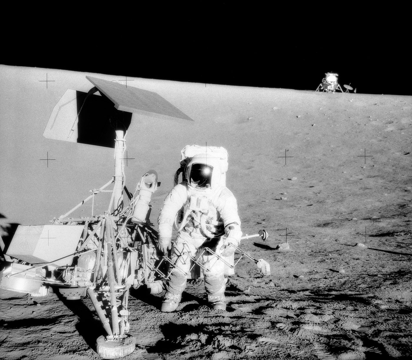 Figure 4 — Apollo 12's Surveyor 3, with the Lunar Module Intrepid on the horizon roughly 200 yards away — the proof that the AGC's descent guidance could land a crew within walking distance of a ch…
