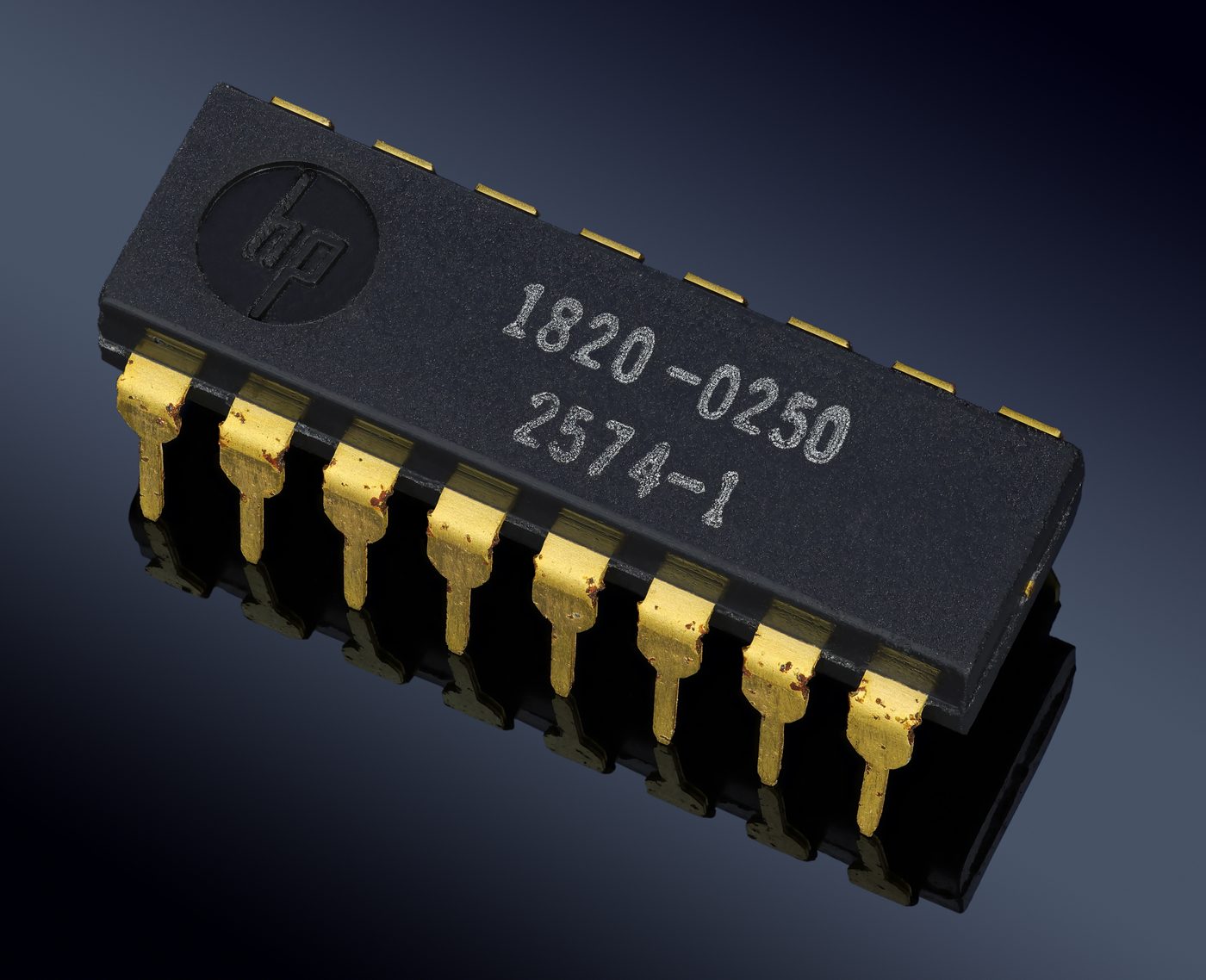 Figure 2 — A silicon integrated-circuit die under the microscope. Apollo's quality-obsessed early demand helped drive IC volume up, prices down, and reliability standards up — accelerating the indu…