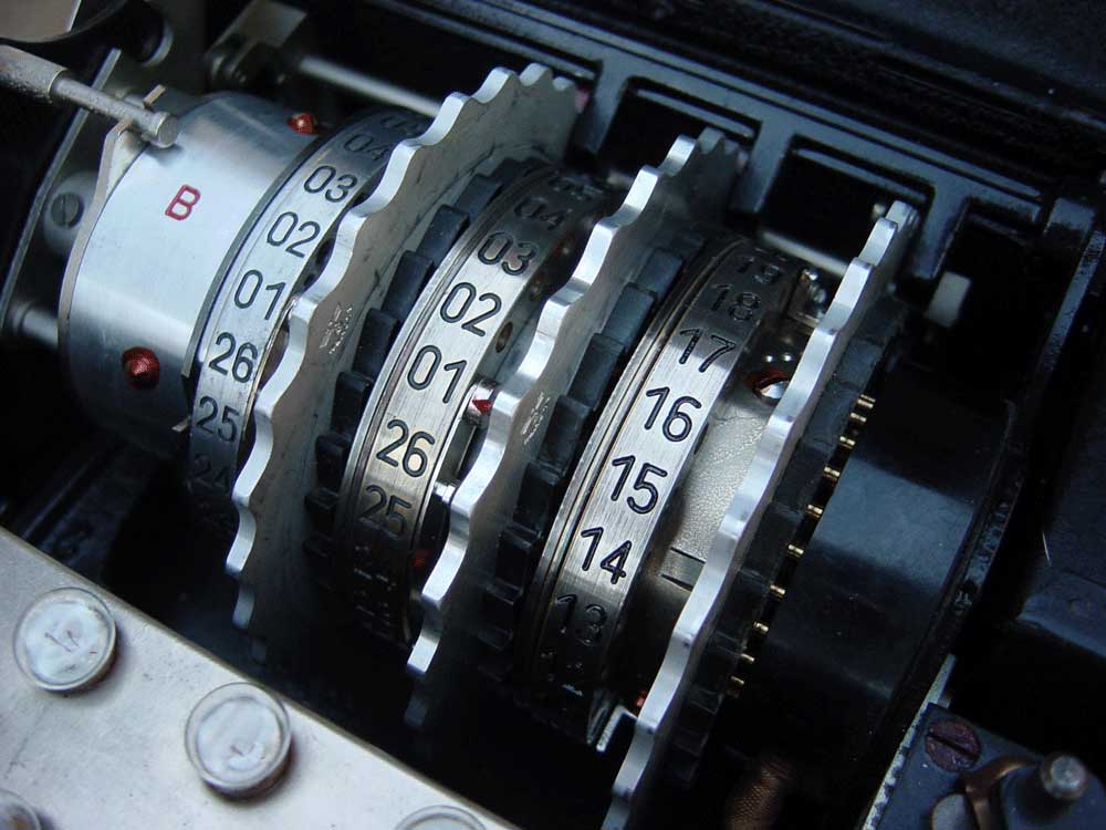 Figure 4 — A set of three Enigma rotors removed from the machine, showing the alphabet rings, finger-wheels and the contact faces by which they connect in series. File:Enigma-rotor-stack.jpg by unk…