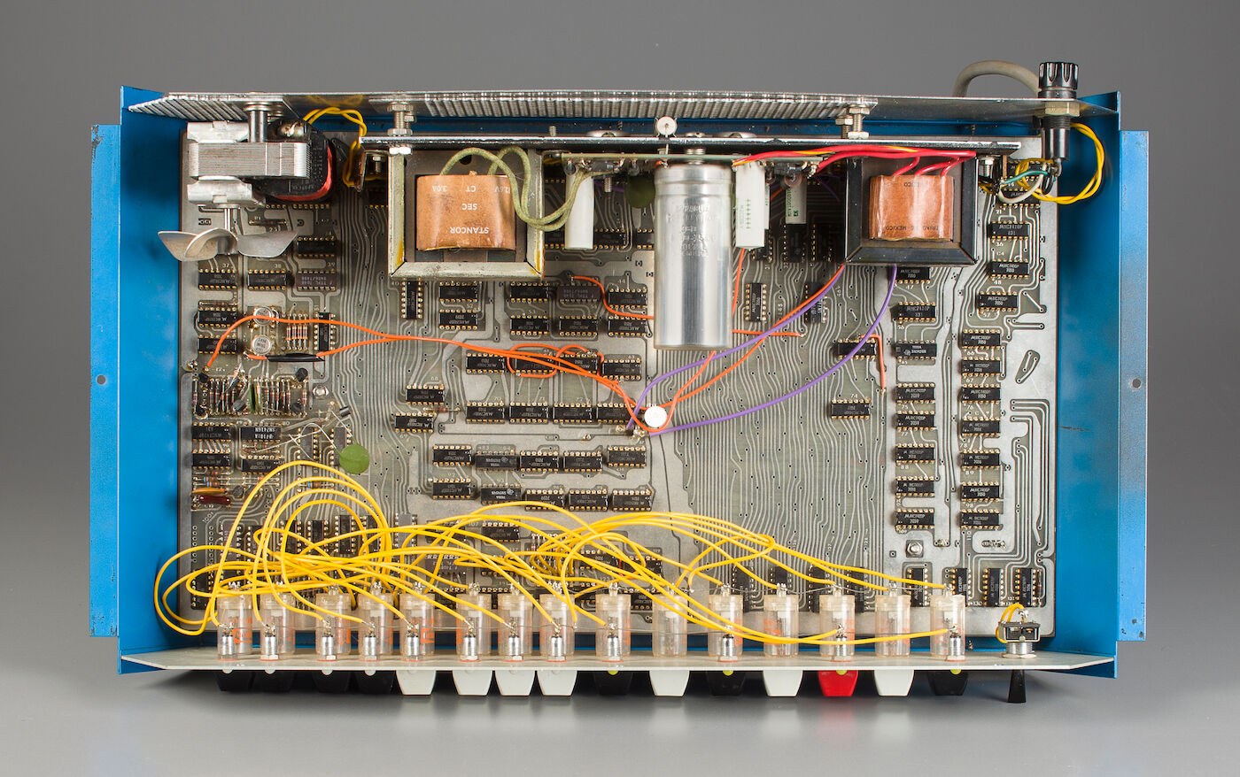 Figure 3 — The prototype with its top removed, as photographed for its sale in 2015. The single logic board fills the floor of the case; the power supplies and their transformers are at the back. The yellow w…