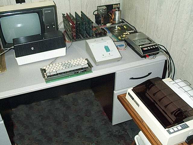 Figure 6 — A hobbyist's expanded KIM-1 system: a portable cassette recorder for program storage at right, a card cage of expansion boards, a video terminal and keyboard in place of the teleprinter, and a prin…