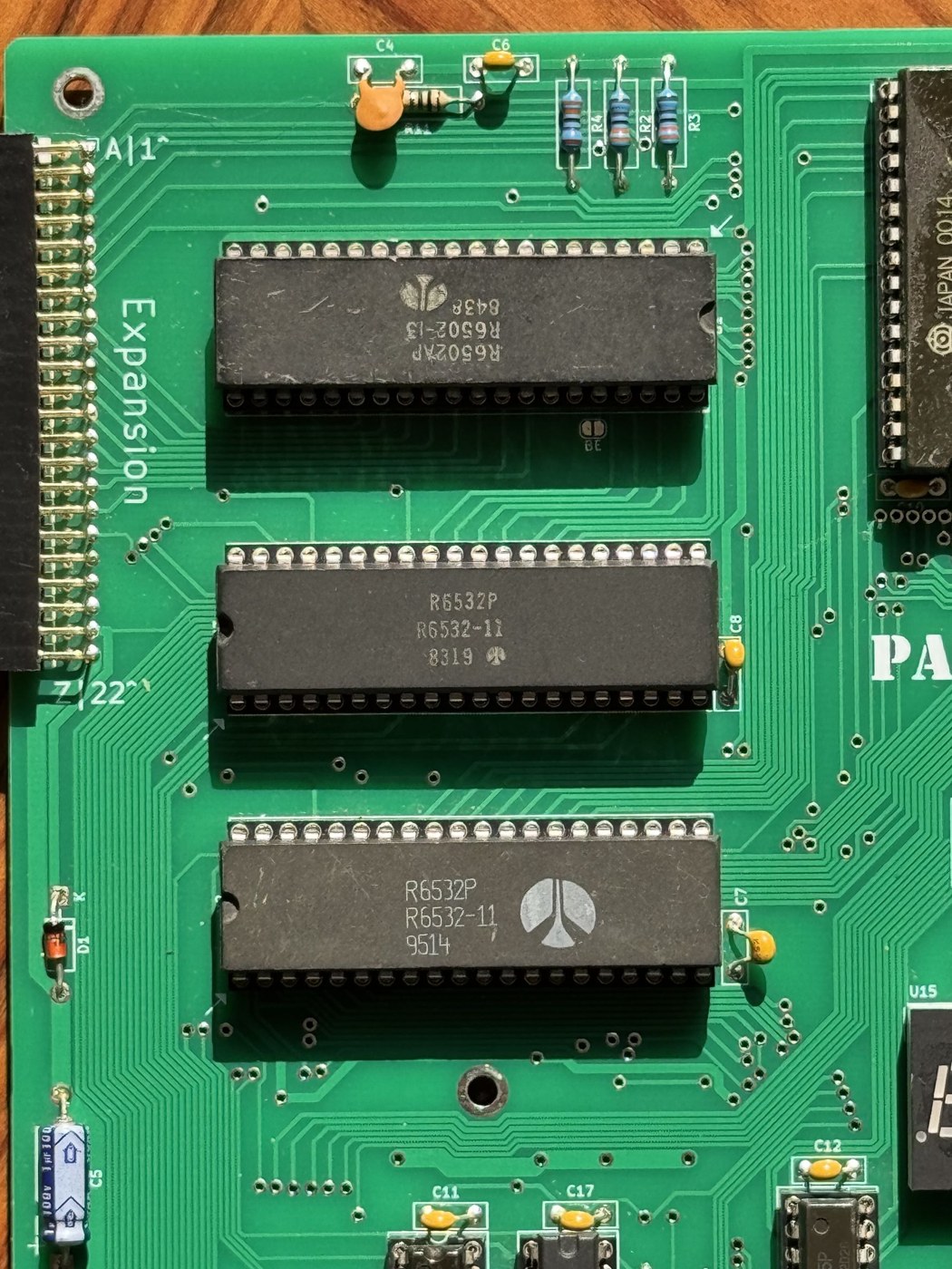 Figure 3 — The column of large chips on a finished PAL-2: a Rockwell R6502AP processor at top and two Rockwell R6532P RIOTs below it, in the positions of the KIM-1's 6502, 6530-002 and 6530-003. The 6532s are…