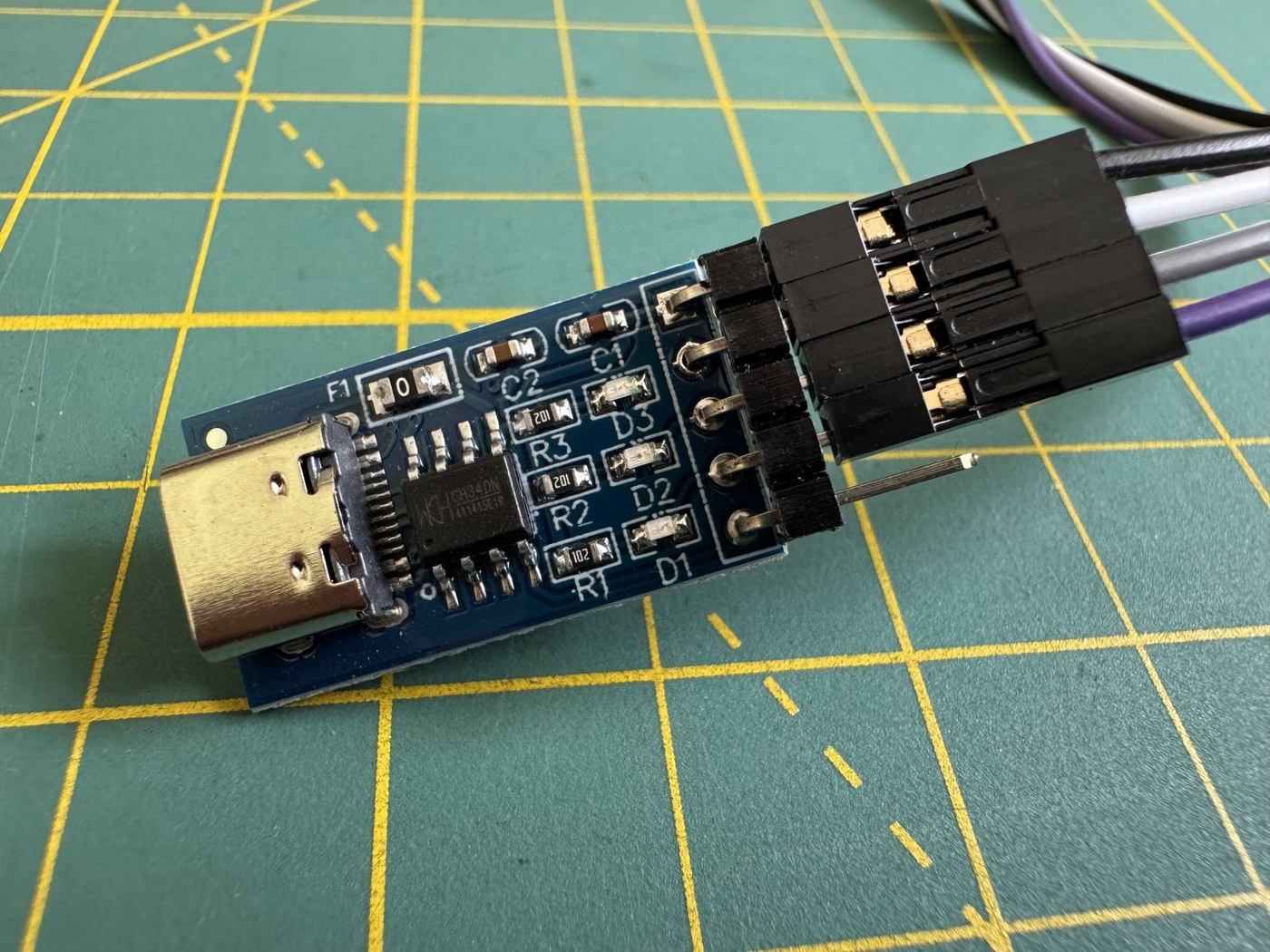 Figure 7 — The USB-to-TTL adapter included with the PAL-2 kit: a USB-C socket at one end and a header carrying ground, 5 V, transmit and receive at the other. Some adapters of this kind lack the resistors tha…