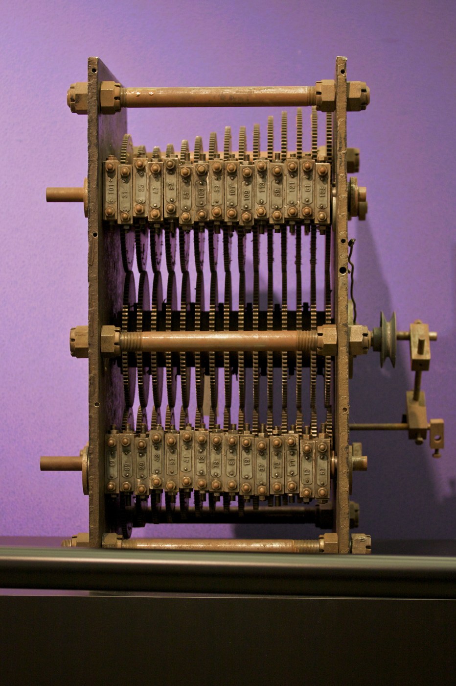 Figure 5 — Lehmer's photoelectric gear sieve of 1932 at the Computer History Museum: a stack of gears with different tooth counts on parallel shafts, each gear drilled at its acceptable residues. A light beam…
