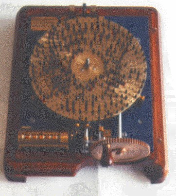 Figure 4 — Carissan's machine à congruences "programmed" for a problem: the fourteen concentric rings carry studs, some fitted with caps, with the counter at lower left and the hand-crank gear at lower right.…