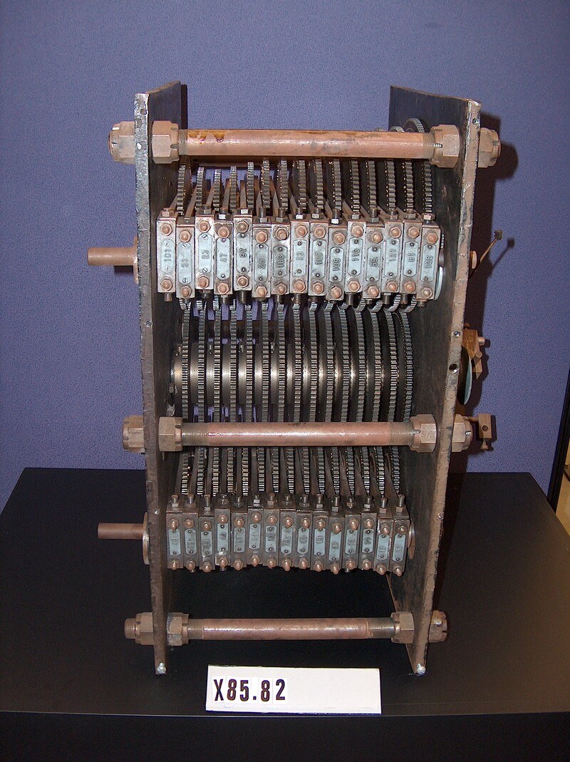 Figure 3 — The surviving gear sieve at the Computer History Museum. Two side plates carry an upper bank of fifteen modulus gears, each in its own labelled bearing block, a central row of driving gears on a si…