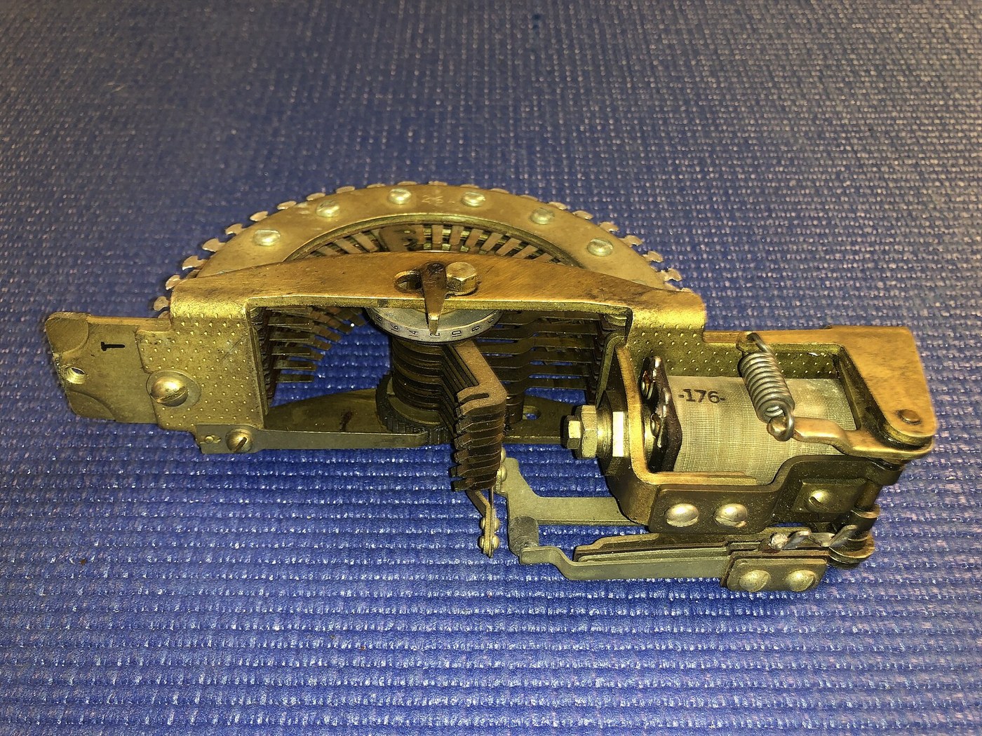 Figure 3 — The same family of switch seen from the side: the double-ended wipers stacked on their shaft inside the half-ring bank, the stepping magnet and its armature at the right, and the drive spring that …