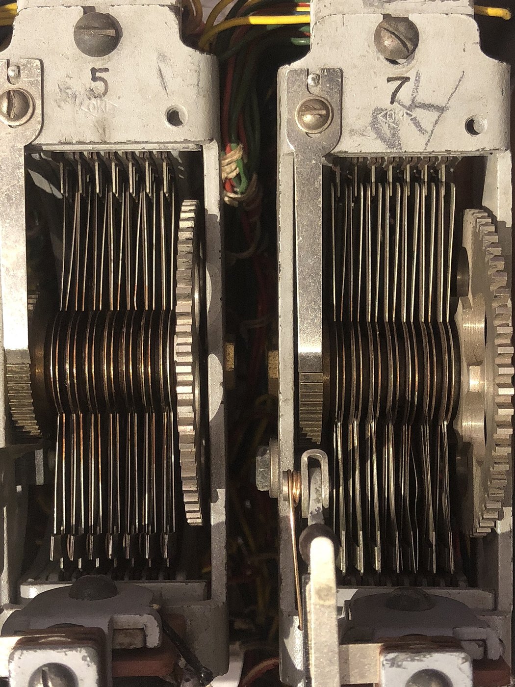 Figure 3 — Two of the three switches seen end-on, with their contact levels (the stacked layers of springs) and the wiper discs between them; the frame castings are stamped 5 and 7. Close photographs like thi…